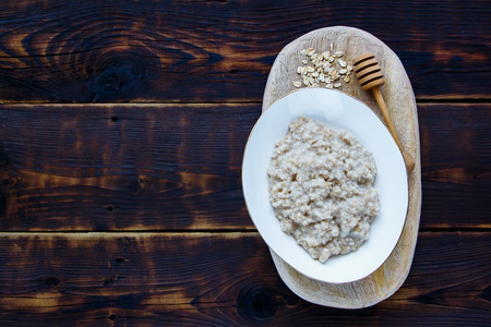 Bowl of  Delicious Homemade oatmeal porridge on dark rustic background.の写真素材