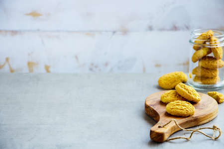 Homemade coconut cookies on wooden board with place for text. White wooden wall as background. Selective Focus.の写真素材
