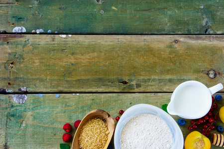 Close up of fresh mixed berries, baking ingredients and utensils on old wooden background, rustic style, copy space, top view.の写真素材