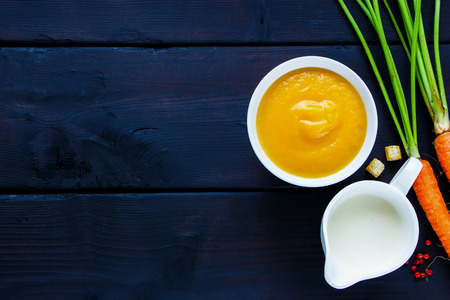 Creamy vegetable soup in bowl over dark wooden background, copy space, top view. Dieting, clean eating, weight loss, vegan, vegetarian, autumn food conceptの写真素材