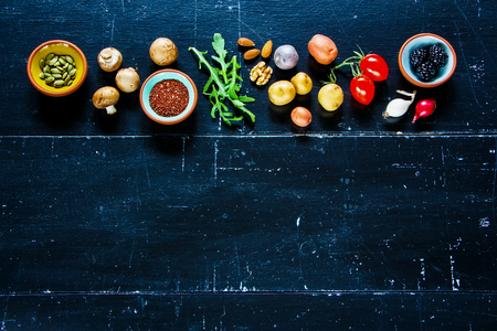 Healthy food clean eating selection of fruit, vegetable, mushrooms, nuts, seeds, superfood, cereals on old wooden background. Ingredients for cooking. Food background on wood. Top view copy space.の写真素材