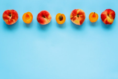 Peach and apricot frame on pastel light blue background flat lay. Summer composition. Top view