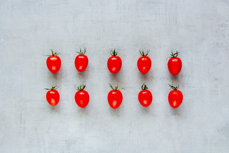 Creative layout made of fresh cherry tomatoes on light background. Healthy cooking. Food concept. Flat lay, top viewの写真素材
