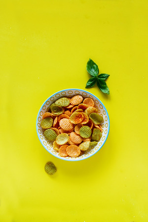 Flat lay of veggie chips on yellow backgroundの写真素材