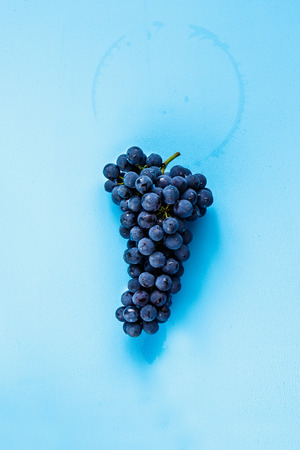 Flat lay of fresh grape on blue backgroundの写真素材