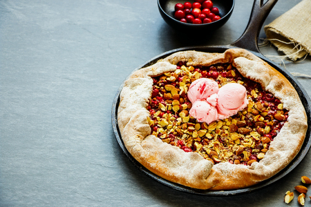 Cranberry and almond pie with ice cream close upの写真素材