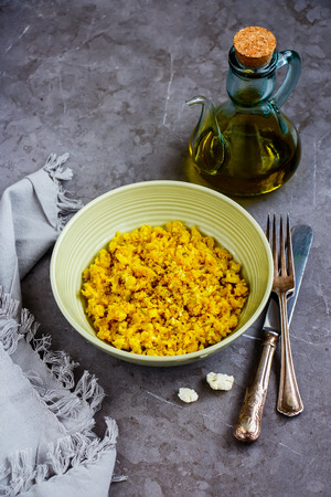 Close up of Cauliflower Rice with spices in bowl and Raw Cauliflower over grey concrete table background - Imageの写真素材