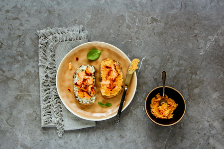 Fresh smoked salmon toasts with soft goat cheese and basil over grey concrete table background. Top view, flat lay - Imageの写真素材