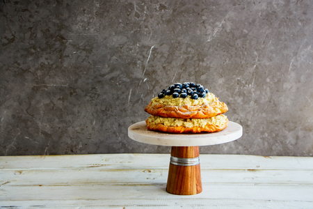 Meringue Pavlova cake with fresh blueberry and mascarpone cream on cake standの写真素材