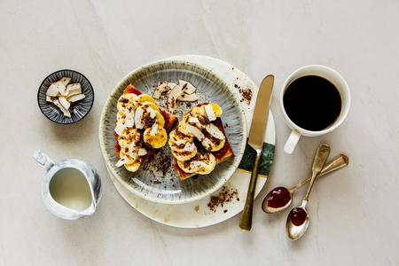 Coffee cup and banana coconut chocolate toast for breakfast flat lay top viewの写真素材