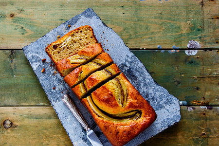 Flat-lay of banana bread cake dessert on stone board captured from aboveの写真素材