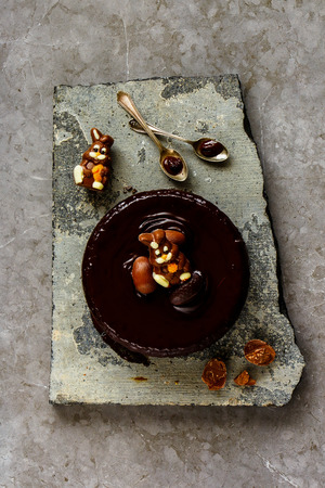 Flat-lay of Easter chocolate cake decorated with chocolate bunnies and eggsの写真素材