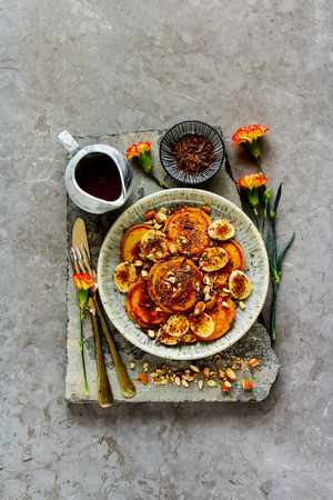 Breakfast, flat-lay of pancakes with banana, chocolate and almonds captured from aboveの写真素材