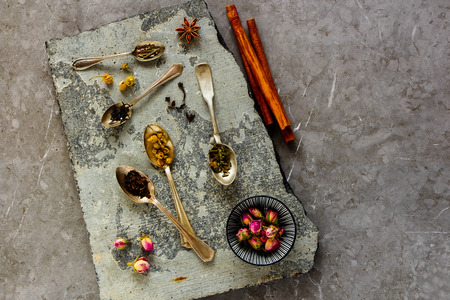 Flat-lay of assortment of dry tea on stone board. Tea types backgound from aboveの写真素材