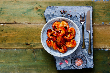 Flat-lay of Grilled pink Prawn Shrimp in plate on stone board from aboveの写真素材