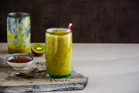 Green smoothie in jars and ingredients on stone boardの写真素材