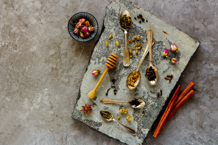 Dry tea and spices on stone board flat lay. Tea types backgound from aboveの写真素材
