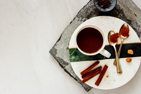Hot chocolate with spices and ingredients above over white table. Winter drink. Flat lay, space.の写真素材