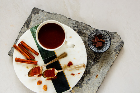 Flat-lay of hot chocolate with spices and ingredients above over white table. Winter drink. Spaceの写真素材