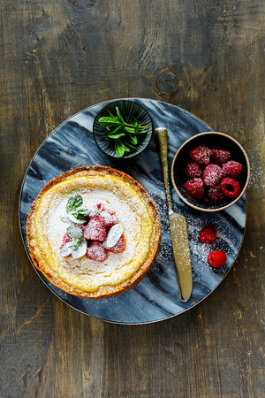Flat-lay of homemade classic cheesecake with raspberry captured from aboveの写真素材