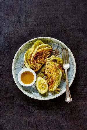 Baked cabbage with mustard sauce in plate flat lay. Healthy food. Style vintage.の写真素材