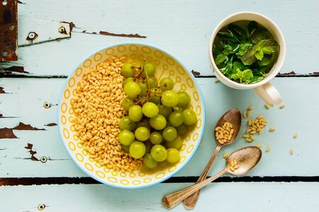 Crispy Rice with green grape and mint tea on turquoise background, flat layの写真素材
