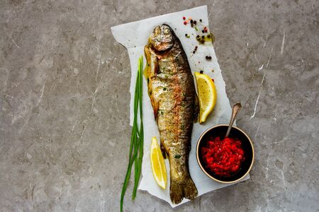 Fresh Baked Trout Fish with Herbs and Lemon, flat layの写真素材