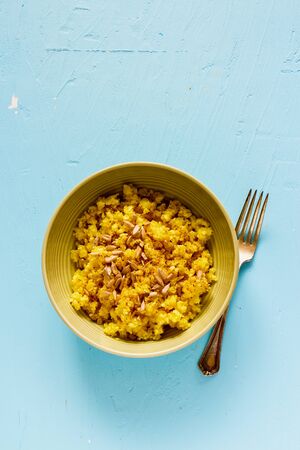 Flat-lay of Cauliflower Rice with spices and sunflower seeds on blue background, top viewの写真素材