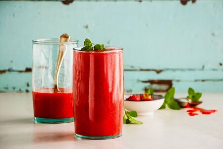 Jars of strawberry smoothie on turquoise backgroundの写真素材