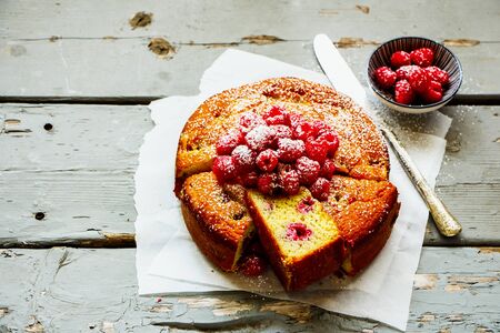 Homemade raspberry yoghurt cake on wooden board, slicedの写真素材