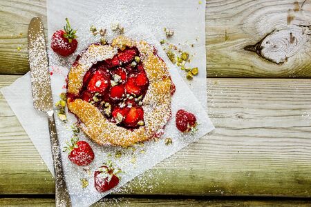 Summer strawberry sweet pie with pistachios flat lay top viewの写真素材