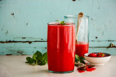Healthy strawberry smoothie jars on turquoise backgroundの写真素材