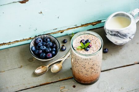 Glass jar of blueberry milkshake on wooden board flat layの写真素材