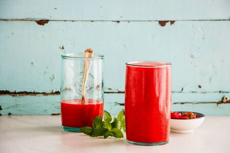 Strawberry smoothie jars on turquoise backgroundの写真素材