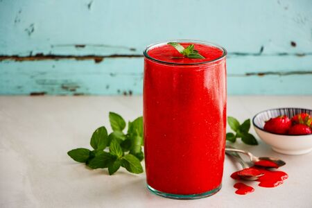 Homemade strawberry smoothie in jar on turquoise backgroundの写真素材