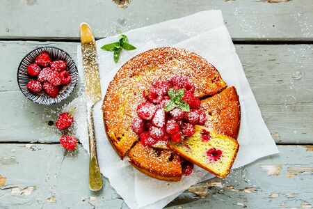 Sliced raspberry yoghurt cake on wooden board, flat layの写真素材