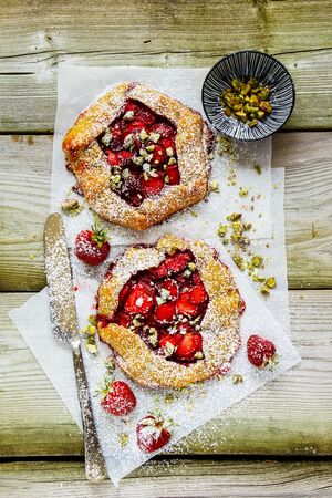 Homemade strawberry sweet summer pie with pistachios flat lay top viewの写真素材