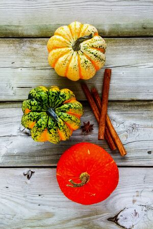 Three pumpkins and autumn background on wooden tableの写真素材