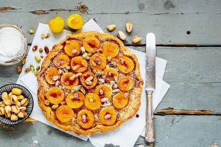 Delicious yellow plum tart on wooden board flat layの写真素材