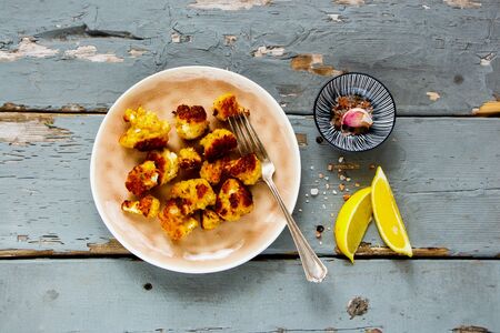 Roast cauliflower on rustic wooden table flat lay. Delicious healthy snack top viewの写真素材