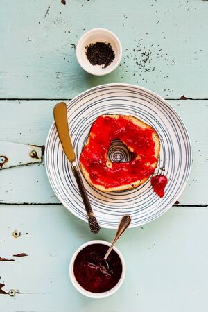 Whole grain bagel with fruit spread flat lay top viewの写真素材