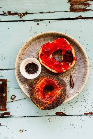 Whole grain bagel with fruit spread in plate flat lay top viewの写真素材
