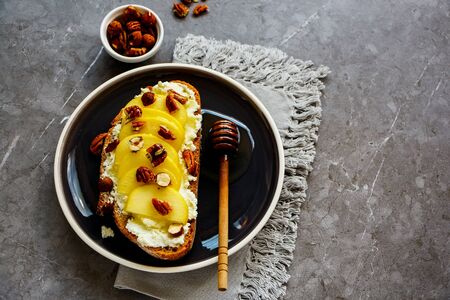 Toast with apple, nuts, honey and ricotta cheese flat layの写真素材