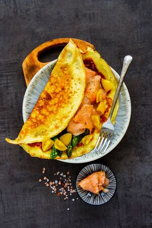 Tasty omelette with smoked salmon in plate flat layの写真素材