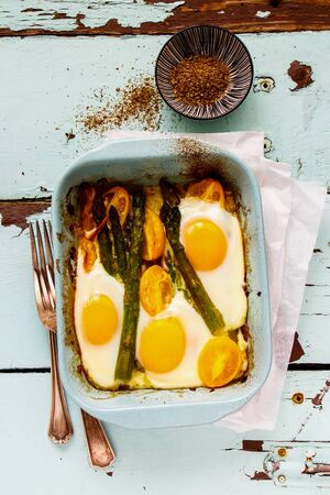 Baked vegetables and eggs on wooden table flat-layの写真素材