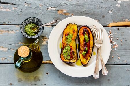 Roasted eggplant in plate with pesto sauce on wooden board flat lay top viewの写真素材
