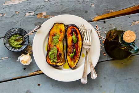 Roasted eggplant with pesto sauce on wooden board from above flat layの写真素材