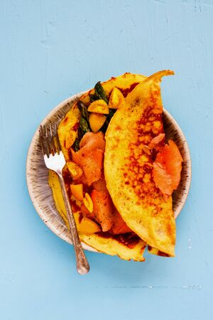 Omelette with smoked salmon on blue background flat layの写真素材