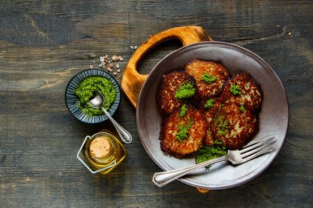 Fresh potato pancakes with pesto sauce on wooden table flat layの写真素材