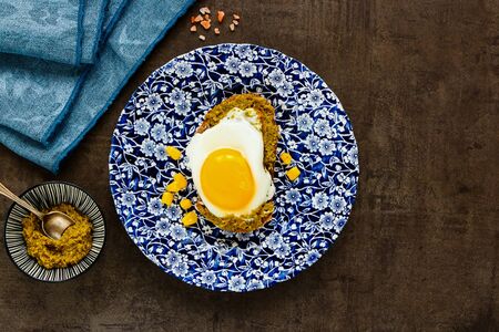 Fried egg sandwich in plate with pesto sauce and sweet corn flat layの写真素材